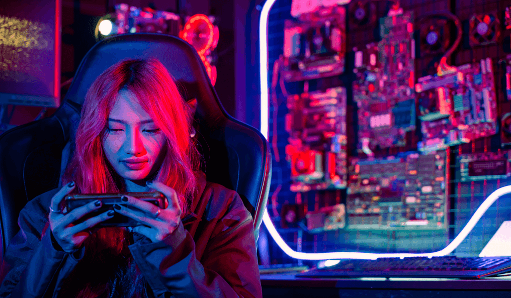 The girl is playing a game on the phone in the arcade